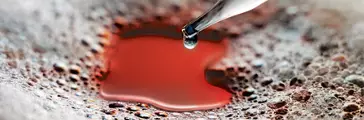 Glass eyedropper dispenses silicone antifoam into a foam covered liquid. The liquid is red. Reference AV03988 Edited by AGP For use on Dow Corning 102F additives website. "Power up your coatings with effective foam control."