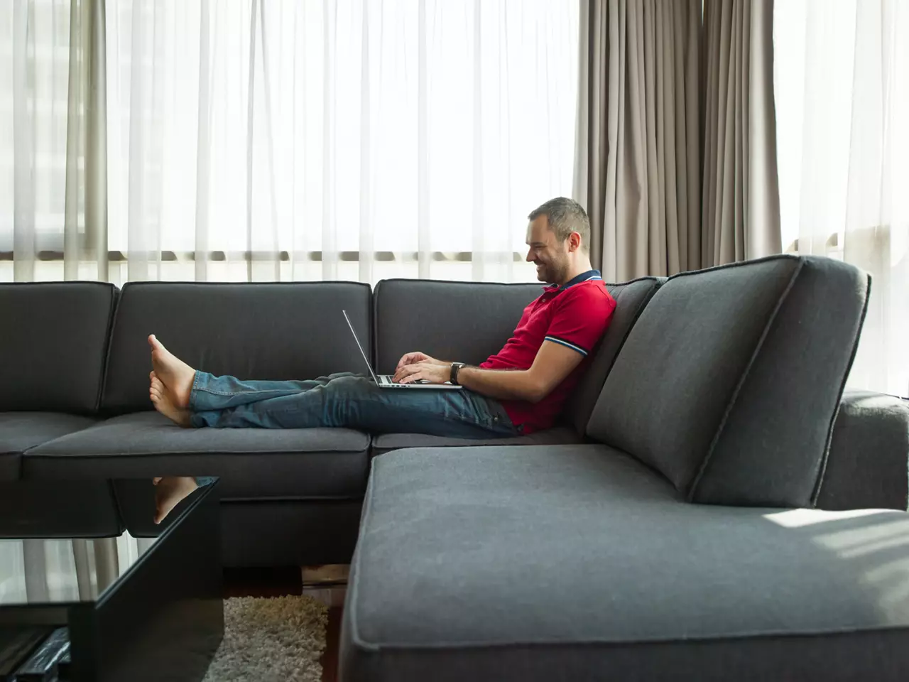 Young man using laptop sitting on sofa