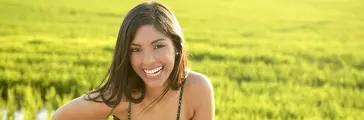 Beautiful brunette indian young woman in the green rice fields meadow