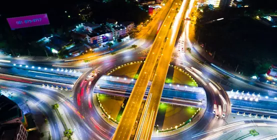 Roundabout intersection city road at night with vehicle light movement