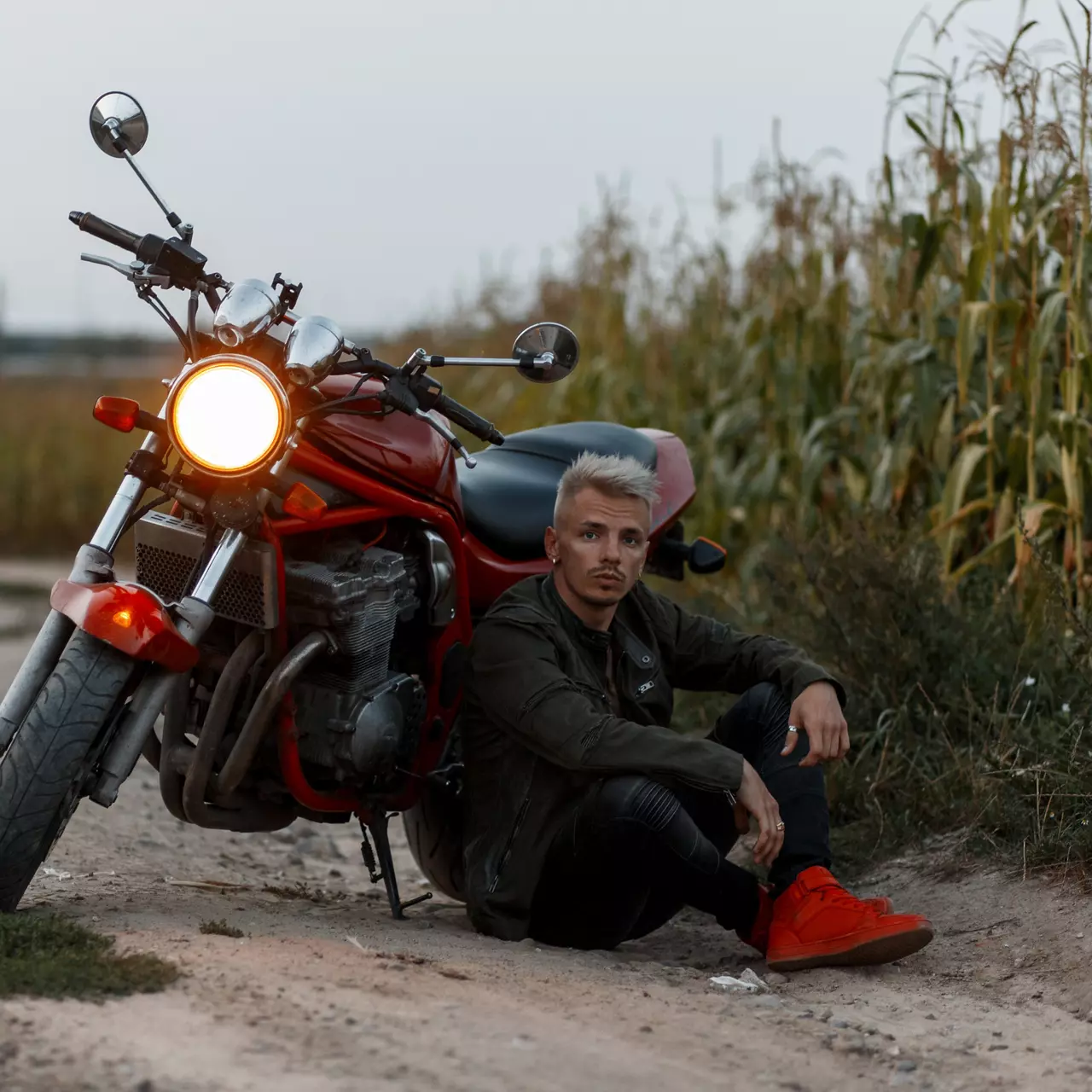 Fashionable Man Sitting Outside by His Motorcycle 