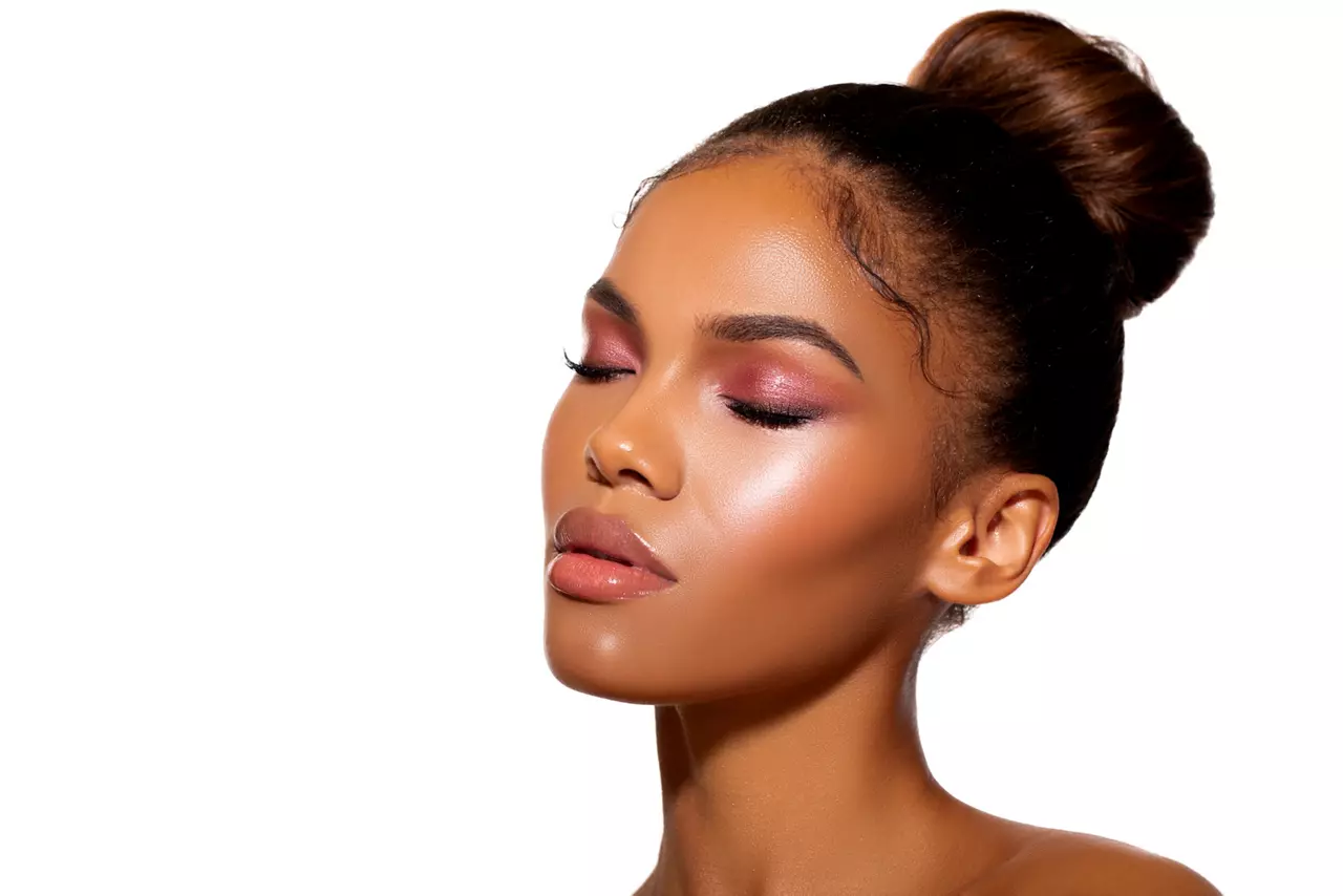 眼睛闭上眼睛的黑人妇女将头发戴在一把高密的发束上