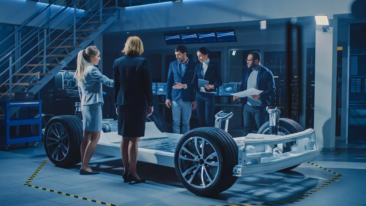 Business people standing around an electric car design