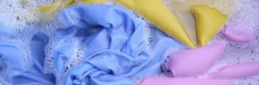 Colorful clothes washed with a basin with soap bubbles