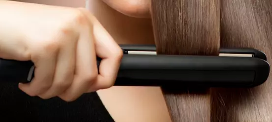Straightener in a woman’s hair
